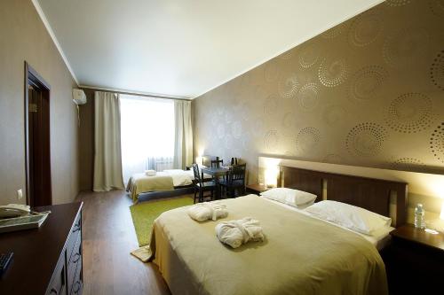 Una habitación de hotel con una cama con toallas. en Green Park Kaluga Hotel en Kaluga