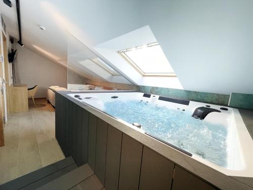 a bathroom with a large bath tub with a skylight at Hostal Restaurante Ibaisek in Zudaire