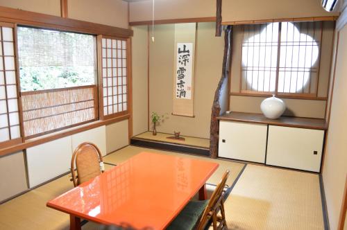 ein Esszimmer mit einem Tisch, Stühlen und Fenstern in der Unterkunft Yadoya Manjiro in Kyoto