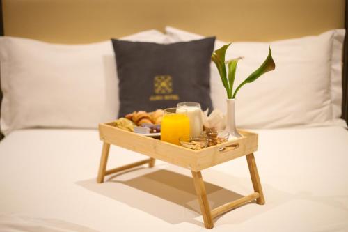 a tray of food and orange juice on a bed at Aliko Hotel in Vlorë