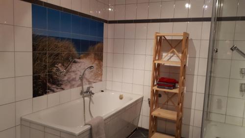 a bathroom with a shower and a bath tub at Staar in Hohenfelde