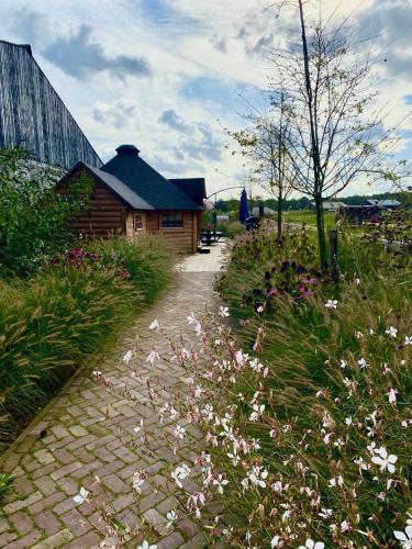 a brick path next to a house and flowers at Luxe Finse Kota van de Zandhoef in Eersel
