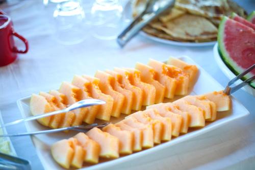 a plate of food with fruit on a table at Aliko Hotel in Vlorë