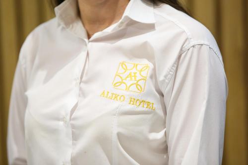 a woman wearing a white shirt with a akoya hotel logo at Aliko Hotel in Vlorë
