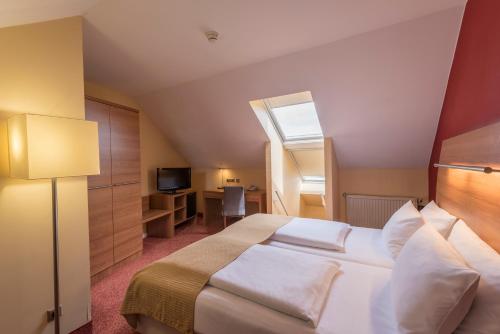 Un dormitorio con una cama grande y una ventana en Holiday Inn Munich Unterhaching, an IHG Hotel, en Unterhaching