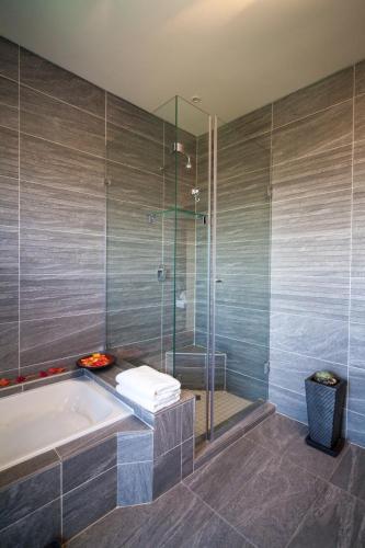 a bathroom with a tub and a glass shower at Over The Moon Guesthouse in Johannesburg