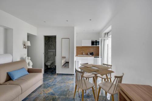 un salon avec un canapé, une table et des chaises dans l'établissement Le Bellevue, à Paris