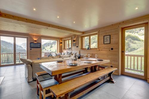 une salle à manger avec une table et un canapé dans l'établissement Le Chalet Blanc, à La Giettaz