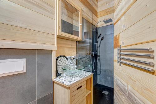 La salle de bains est pourvue d'une douche et d'un lavabo. dans l'établissement Le Chalet Blanc, à La Giettaz