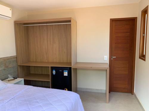 a bedroom with a bed and a wooden cabinet at Pousada Maresia in Fernando de Noronha