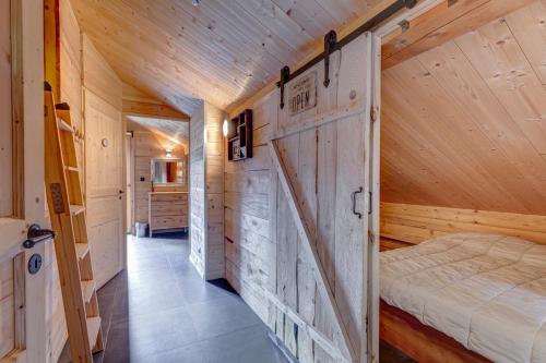 une chambre avec un lit et un mur en bois dans l'établissement Le Chalet Blanc, à La Giettaz