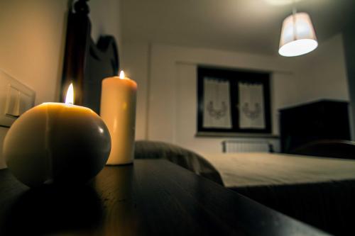 a candle sitting on a table next to a table with a bed at Campo Felice Experience in Rocca di Cambio