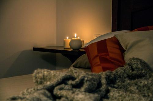 a bed with two candles and a table with a blanket at Campo Felice Experience in Rocca di Cambio