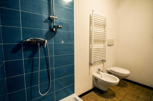 a blue tiled bathroom with a toilet and a shower at Campo Felice Experience in Rocca di Cambio