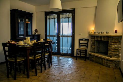 a dining room with a table and chairs and a fireplace at Campo Felice Experience in Rocca di Cambio