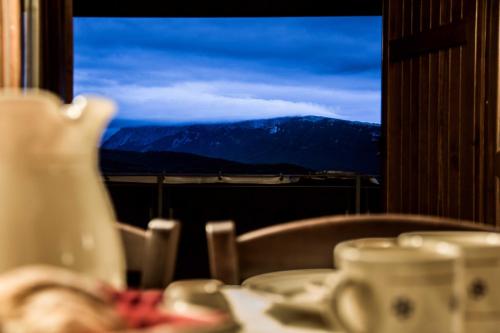 a table with a view of a mountain from a window at Campo Felice Experience in Rocca di Cambio