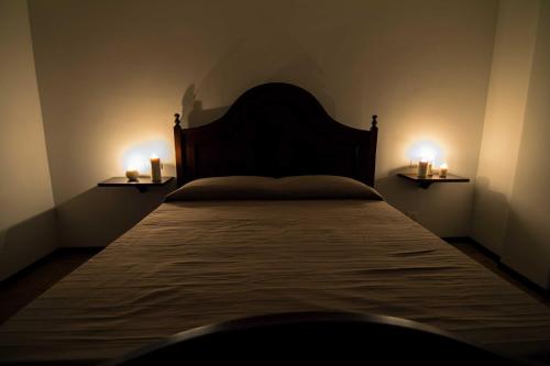 a bedroom with a bed with two candles on the sides at Campo Felice Experience in Rocca di Cambio
