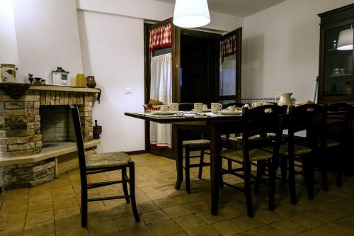 a dining room with a table and chairs and a fireplace at Campo Felice Experience in Rocca di Cambio