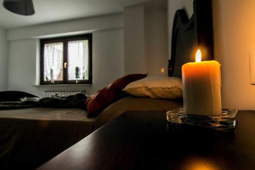 a candle sitting on a table in a living room at Campo Felice Experience in Rocca di Cambio