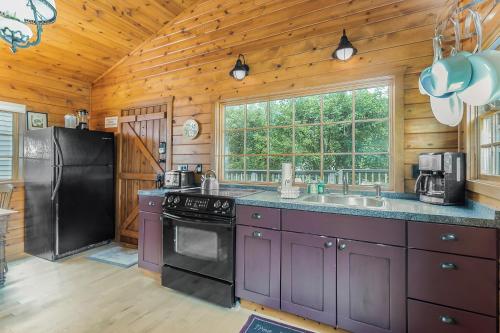 a kitchen with purple cabinets and a black refrigerator at Peterson Mill in Saugatuck