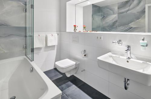 La salle de bains blanche est pourvue d'un lavabo et de toilettes. dans l'établissement Bei Meyers - Leipzig Neue Messe, à Leipzig