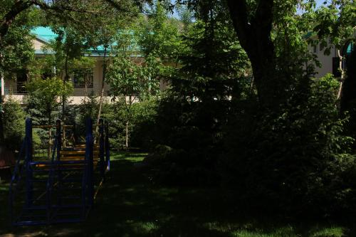 a playground in a yard with a tree and a building at HUMSON BULOQ SANATORIUM in Khumson
