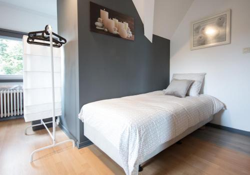 a small bedroom with a bed in a room at Logies De Witte Hoeve in Oudenaarde