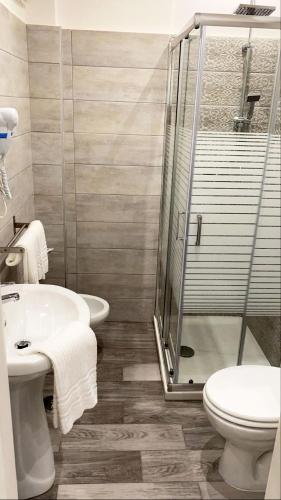 a bathroom with a shower and a toilet and a sink at Hotel stranamore in Varcaturo