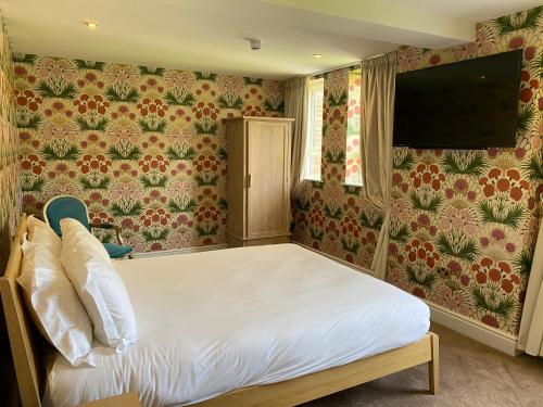a bedroom with a bed and a flat screen tv at RainHill Hall Hotel in Rainhull
