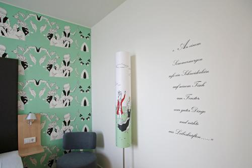 a book page of a room with a wall with a wallpaper at Grimm´s Berlin Potsdam in Teltow