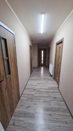 a hallway of an empty room with wooden doors at W20 Hostel in Golędzinów