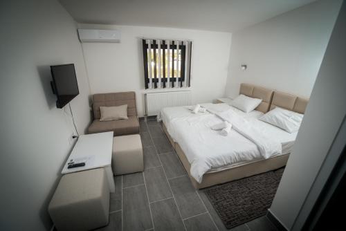 a bedroom with a large bed and a chair at Prenociste ADRIA in Vranje