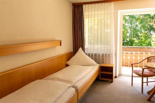 フロイデンシュタットにあるHotel Schwarzwald Freudenstadtのベッド2台と窓が備わるホテルルームです。