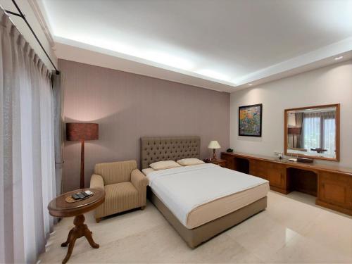 a hotel room with a bed and a chair at Via Renata Prapanca in Jakarta