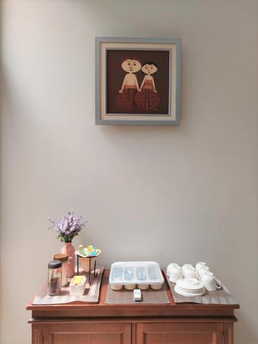 a wooden table with a picture on the wall at Via Renata Prapanca in Jakarta