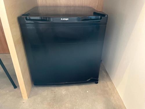 a black refrigerator in a corner of a room at Hostel Have a Nice Day! ドミトリー 個室ルームあり#HVNI in Odawara