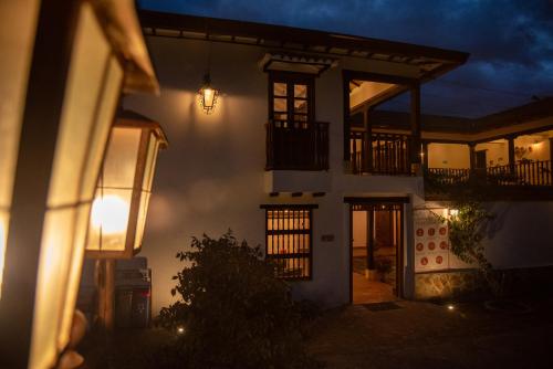 a house at night with a light on the side at Hotel Campestre El Portón de Los Jeroglíficos in Ramiriquí
