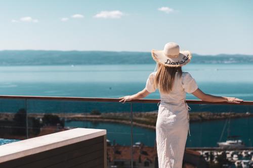 a woman in a hat standing on top of a building at Marvie Hotel & Health in Split