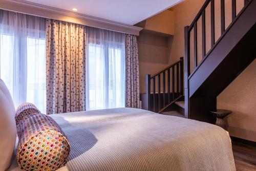 a bedroom with a large bed and a staircase at Maison Axel Opéra Paris in Paris