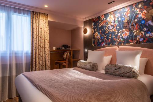 sypialnia z dużym łóżkiem i obrazem na ścianie w obiekcie Maison Axel Opéra w Paryżu