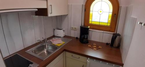 una pequeña cocina con fregadero y ventana en Haus Thaler en Reith im Alpbachtal