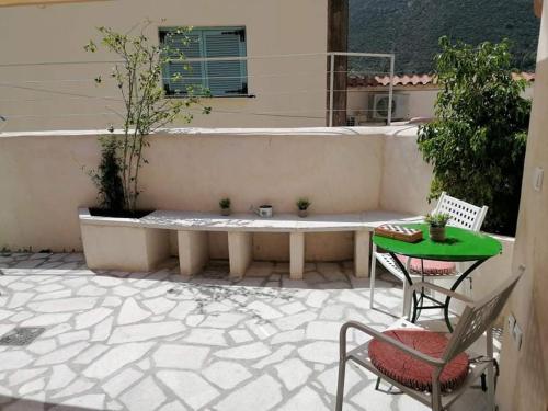 a bench on a patio with a table and chairs at Rodomelo Cute Studio 2 in Leonidion