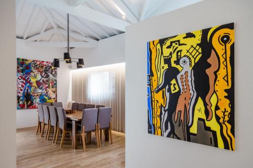 a dining room with a large painting on the wall at casasun777, deixe-se surpreender e deslumbrar! in Braga