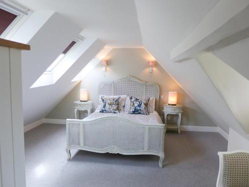 a bedroom with a white bed in a attic at Little Evanses in Axminster