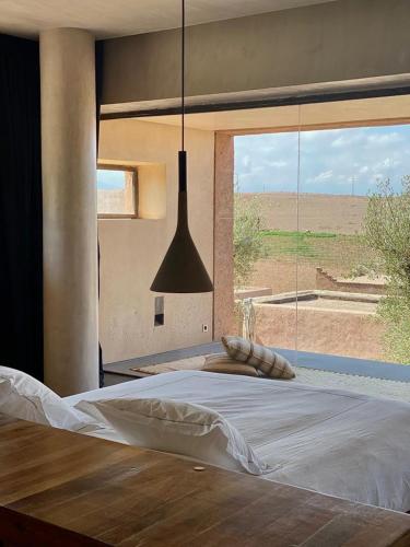 a bedroom with a large bed and a large window at Villa K by Studio KO - Private Luxury Estate Marrakech in Marrakesh