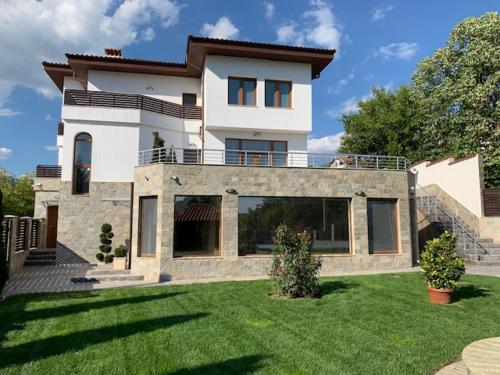 a large house with a lawn in front of it at Луксозна вила - Стрелча, джакузи с минерална вода in Strelcha