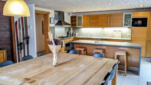 a kitchen with a wooden table with a vase on it at Chalet Robin - spa- multipass- terrain de pétanque in Morzine