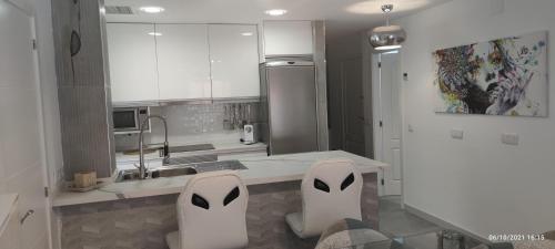 a kitchen with white counters and white appliances at Tus vacaciones en el corazón de Alicante! in Alicante