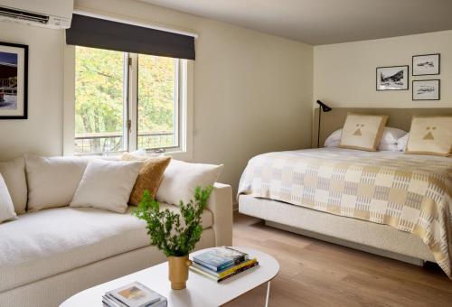 a bedroom with a bed and a couch at Tälta Lodge, a Bluebird by Lark in Stowe