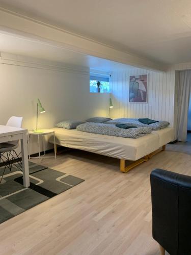 um quarto com uma cama grande e uma secretária em H. C. Lumbyes Vej - kælderlejlighed em Odense